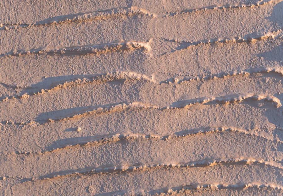 Eine kalkverputzte Wand auf Tinos bei Sonnenuntergang: das Streiflicht hebt jeden Zug der Hand hervor, der in der Materie geblieben ist.